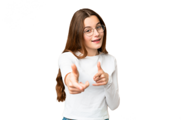 Teenager girl over isolated chroma key background pointing to the front and smiling