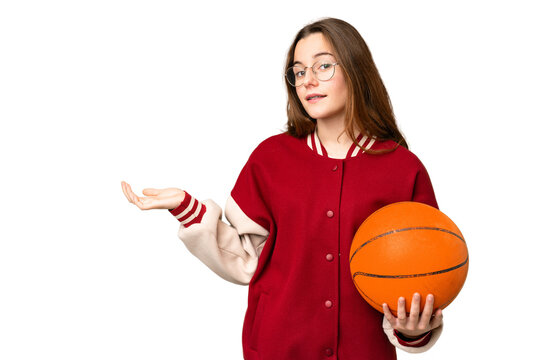 Teenager girl playing basketball over isolated chroma key background extending hands to the side for inviting to come - Powered by Adobe