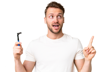 Young caucasian man shaving his beard  over isolated chroma key background intending to realizes the solution while lifting a finger up