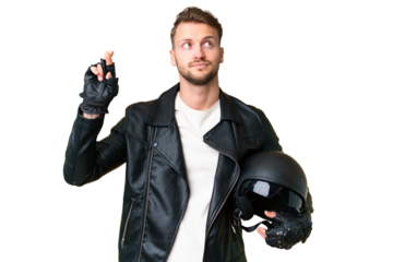 Young caucasian man with a motorcycle helmet over isolated chroma key background with fingers crossing and wishing the best