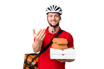 Young delivery man taking a takeaway food over isolated chroma key background inviting to come with hand. Happy that you came
