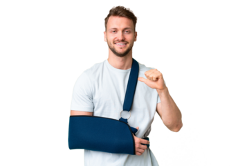 Young caucasian man with broken arm and wearing a sling over isolated chroma key background proud and self-satisfied