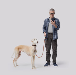 Pet owner walking the dog and checking the smartphone