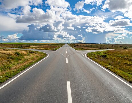 Three roads converge beneath a dramatic sky over fields