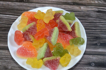 plate of Jelly candy, Gummies, gummi candies, gummy candies, or jelly sweets,  gelatin-based chewable sweets. Gummy sour jelly sweets candies in various shapes, confectionery for children