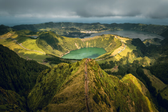 Aerial view over the Boca Do Inferno (devil's mouth), at Sete Cidades volcano caldera during sunny day with dramatic sky with green lake Lago Santiago in Sao Miguel, Azores Islands, Portugal. 