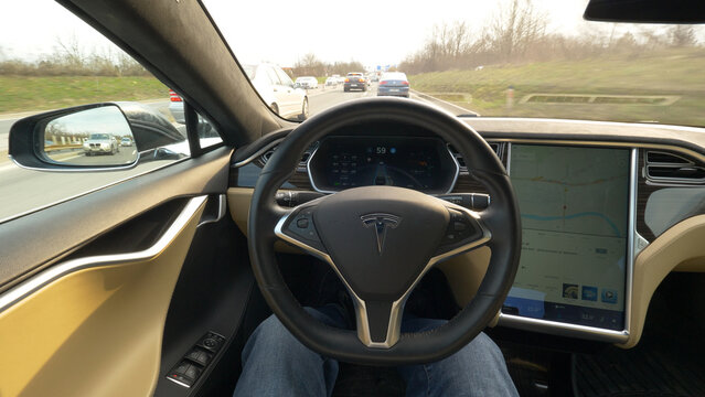 POV: Man sits in the driver&rsquo;s seat of a cool autonomous car driving down highway