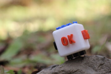 自然の中に佇むOKの文字が書かれたキューブ