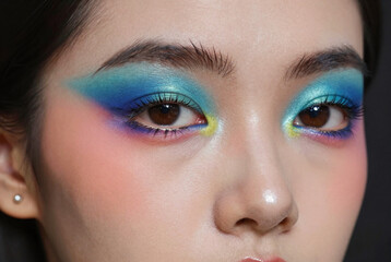 Naklejka premium Vibrant blue and green eyeshadow makeup on a woman's eyes.