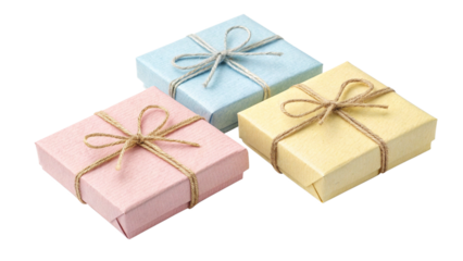 Three small pastel colored jewelry gift boxes tied with rustic twine bows arranged together on transparent background
