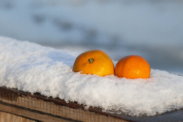 Juicy ripe tangerines on the snow.Popular citrus fruits.