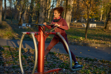 Woman using outdoor fitness equipment