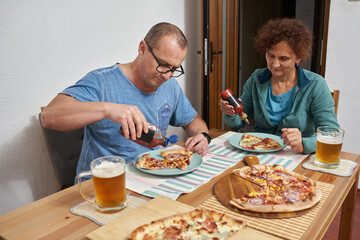 Couple seasoning pizza at dinner © Xalanx