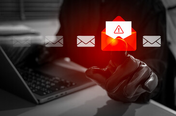 Anonymity hacker or scammer wearing black gloves opens red envelope alert email on laptop. Phishing, malware, or virus attacks. Concept of cybercrime, data breach, and online email security threats.