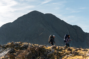 Determined hiking friends advancing steadily beneath dominant peak