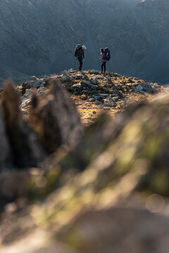 Minimal silhouettes of weekend adventurers standing united against expansive mountain void