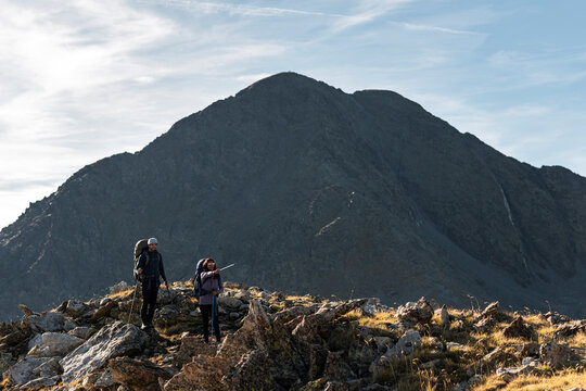 Insightful female hiker indicating route across exposed mountain ridge