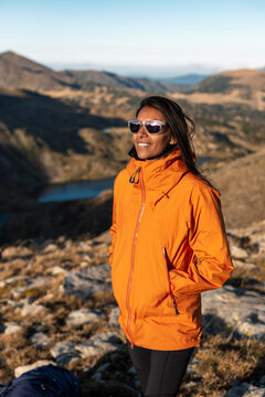 Adventurous outdoor woman standing relaxed within protective mountain layer