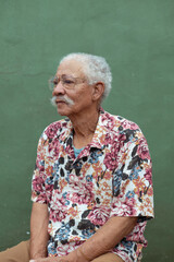 Portrait of senior man isolated against green wall