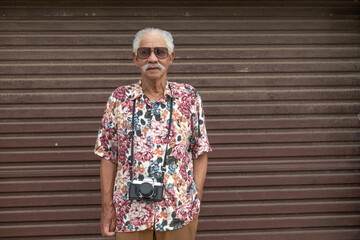 Portrait of senior man with vintage camera