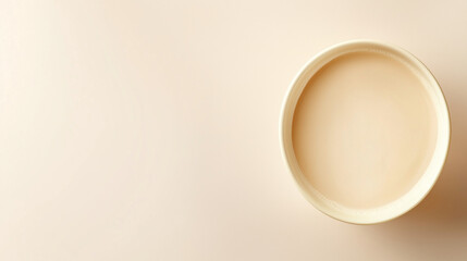 Minimalist top-down view of a cup with a creamy beverage against a soft background for relaxation themes with copy space