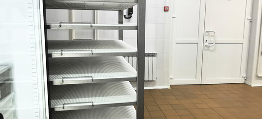 Empty shelves in a storage room at a facility during daylight hours