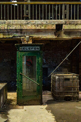 Abandoned telephone booth inside industrial building