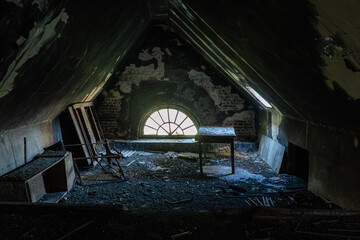 Abandoned attic room with arched window
