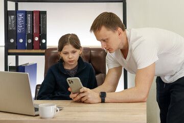 Obraz premium Man observing child using mobile phone in office