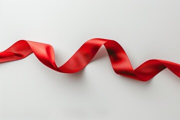 Red satin ribbon forming a curve on a white background, perfect for representing holidays, gifts, and special occasions