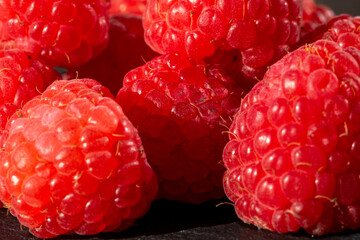 Fresh appetizing ripe raspberries in a detailed macro shot showing texture and vibrant red color