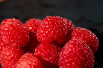 Fresh appetizing ripe raspberries in a detailed macro shot showing texture and vibrant red color