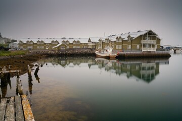view of the harbour and hotel in Siglufjordur with a fishing trawler in the foreground