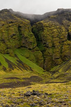 frontal view of the highland cliffs and the mythical Raudfelsgja gorge on a foggy and overcast day