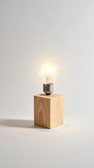 Illuminated light bulb on a wooden block, symbolizing innovation and bright ideas.