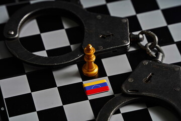 Golden king chess piece with Venezuelan flag with handcuffs.