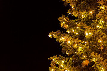 Decorated Christmas tree with glowing star lights against dark night sky, Germany, Augsburg, 19 December 2025