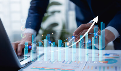 Businessman analyzing company metrics on tablet and laptop, reviewing digital performance dashboards, guiding strategic planning, market analysis, and data-driven business decisions.