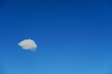 Petit nuage blanc sur fond de ciel bleu.