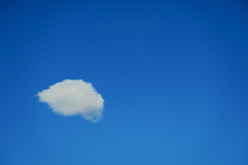 Petit nuage blanc sur fond de ciel bleu.