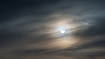 High altitude view of dark altostratus clouds and sun disk above a dense cloud layer

