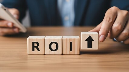 A person's hands arranging wooden blocks to spell ROI with an upward arrow, symbolizing increased Return on Investment and business growth.