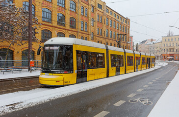Berlin Wintereinbruch mit Schneefall in Berlin Schöneweide / Edisonstrasse, Langer Zug der Metrotram der Linie M17 hält im winterlichen Berlin im Bezirk Treptow Köpenick © Maurice Tricatelle