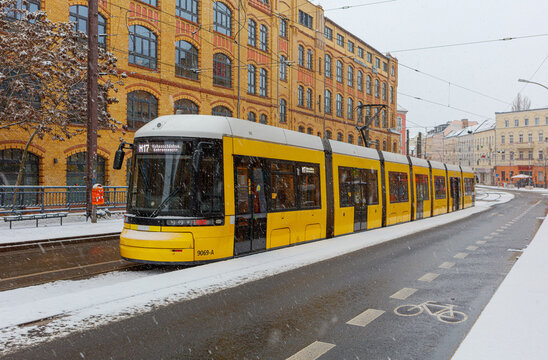 Berlin Wintereinbruch mit Schneefall in Berlin Sch&ouml;neweide / Edisonstrasse, Langer Zug der Metrotram der Linie M17 h&auml;lt im winterlichen Berlin im Bezirk Treptow K&ouml;penick