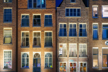 Damrak, Amsterdam, Netherlands. View of the facades of houses in the historical part of the city. Famous Dutch architecture. A cityscape in the evening. Travel photography. 
