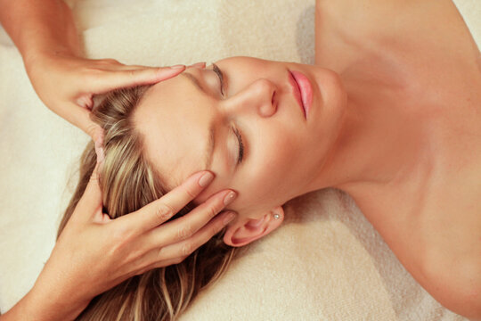 Ojo Caliente, New Mexico, United States. Beautiful blond woman getting a head and facial massage. 