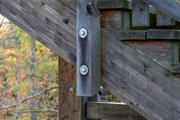 Wooden stair beam with bolted connections and signs of use.
