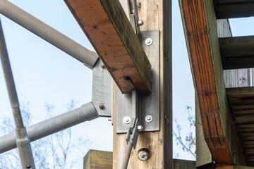 The connecting node of a wooden beam and a metal plate in the frame of the tower.