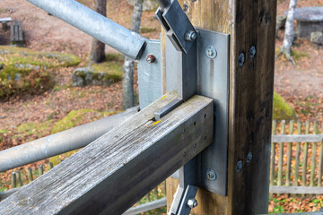 A wooden beam with metal diagonal supports for the load-bearing structure.