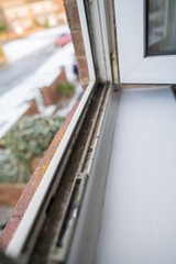 Dirty plastic window. Dust-covered plastic window frame and sill with dirt buildup and stains. Spring home cleaning concept